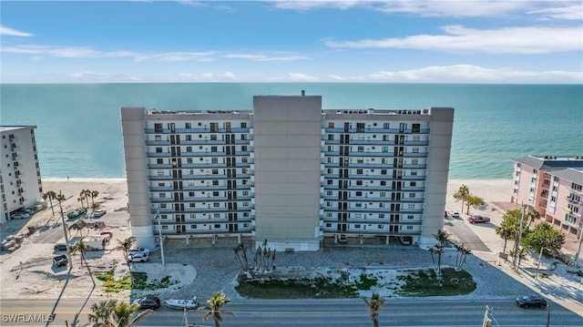 view of building exterior featuring a water view and a view of the beach