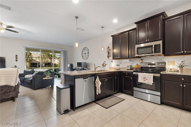 kitchen featuring pendant lighting, sink, stainless steel appliances, light stone counters, and kitchen peninsula