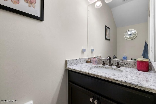 bathroom with vanity and vaulted ceiling