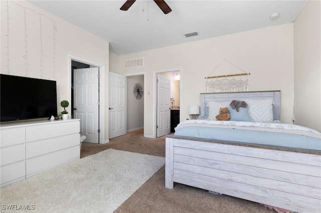 bedroom with light colored carpet, ceiling fan, and ensuite bathroom