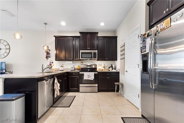 kitchen with pendant lighting, sink, light tile patterned floors, appliances with stainless steel finishes, and kitchen peninsula