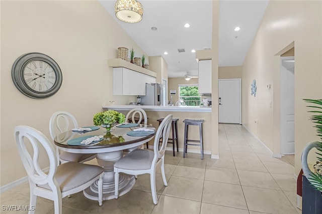 dining room featuring vaulted ceiling and light tile patterned flooring