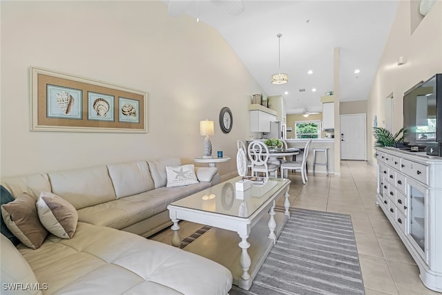 living room featuring ceiling fan, high vaulted ceiling, and light tile patterned floors