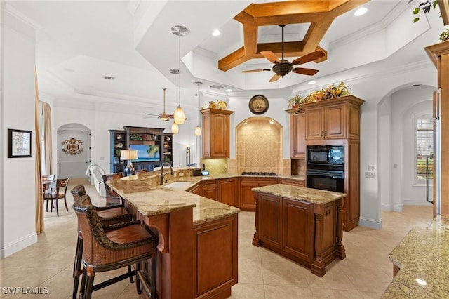 kitchen with a kitchen breakfast bar, coffered ceiling, black appliances, decorative light fixtures, and kitchen peninsula