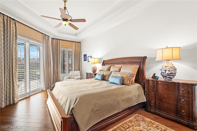 bedroom featuring crown molding, a tray ceiling, dark hardwood / wood-style flooring, ceiling fan, and access to exterior