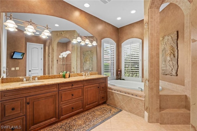 bathroom featuring vanity, tiled tub, and tile patterned flooring