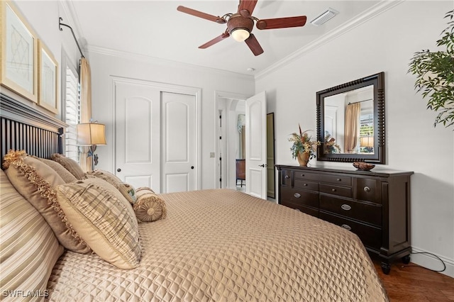 bedroom featuring dark hardwood / wood-style flooring, crown molding, a closet, and ceiling fan