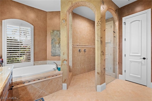 bathroom with tile patterned flooring, vanity, and plus walk in shower