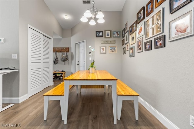 dining area featuring hardwood / wood-style floors and a notable chandelier