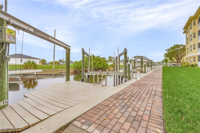 dock area featuring a lawn and a water view