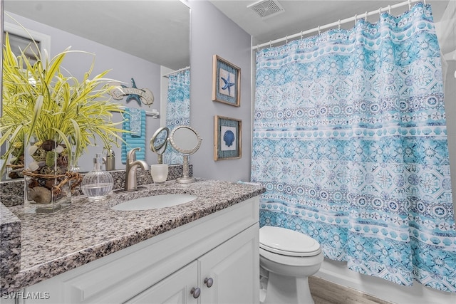 bathroom featuring hardwood / wood-style flooring, toilet, and vanity