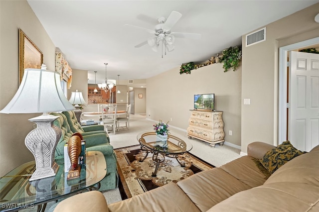 living room featuring ceiling fan with notable chandelier and carpet