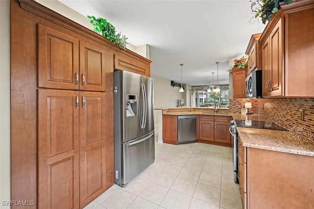 kitchen with sink, tasteful backsplash, light tile patterned floors, pendant lighting, and stainless steel appliances