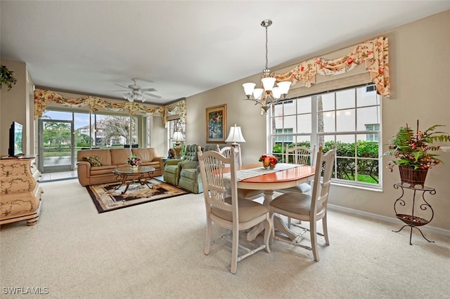 carpeted dining room featuring ceiling fan with notable chandelier