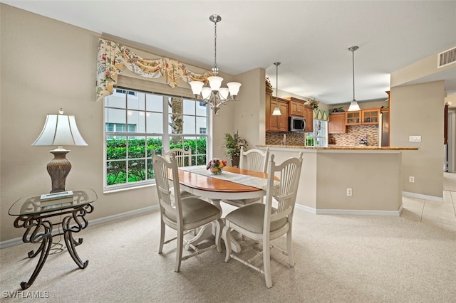 carpeted dining space featuring a chandelier