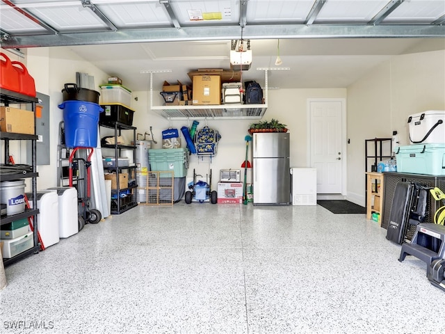 garage featuring stainless steel refrigerator and a garage door opener