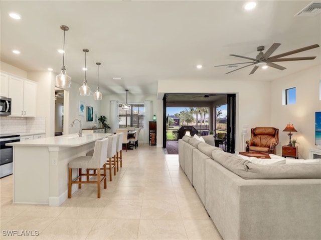 living room with light tile patterned floors, recessed lighting, visible vents, and ceiling fan