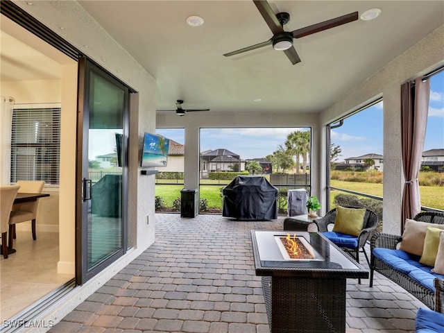 view of patio featuring area for grilling, an outdoor living space with a fire pit, and ceiling fan