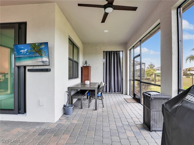 sunroom featuring ceiling fan