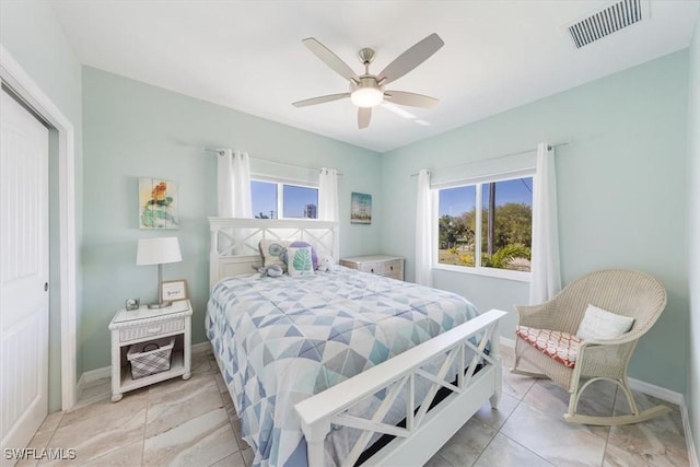 bedroom with light tile patterned flooring, multiple windows, a closet, and ceiling fan