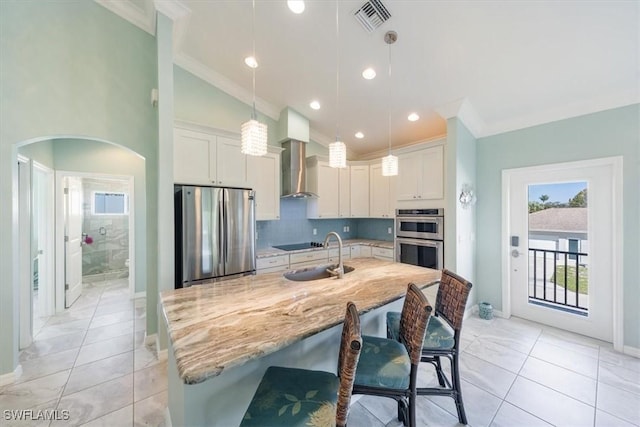 kitchen featuring sink, a kitchen island with sink, appliances with stainless steel finishes, and pendant lighting