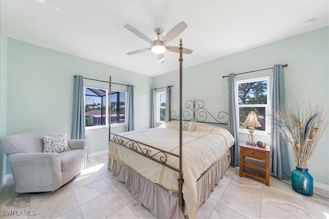 tiled bedroom with ceiling fan and multiple windows