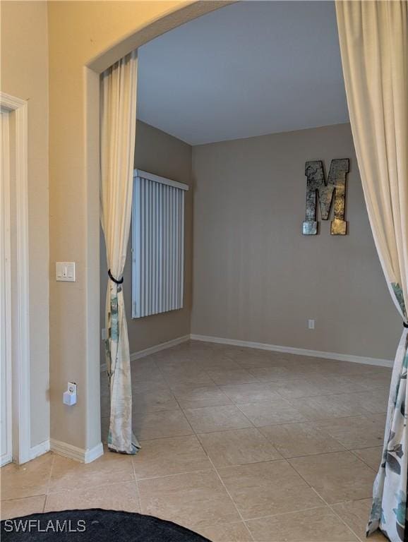 interior space with baseboards and tile patterned floors