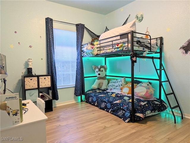 bedroom with baseboards and wood finished floors