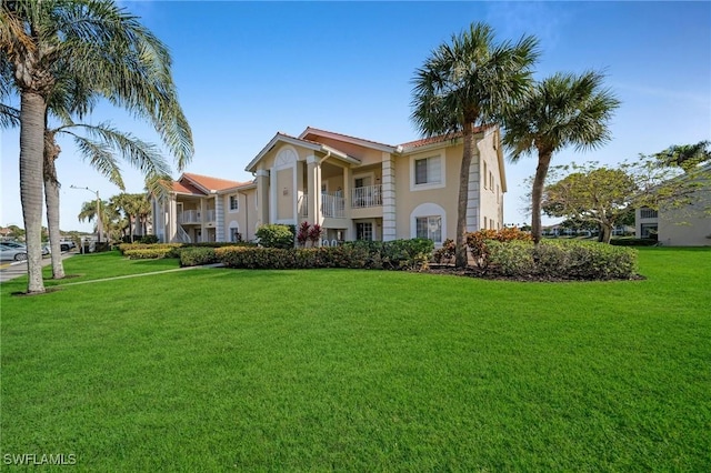 view of front facade featuring a balcony and a front lawn