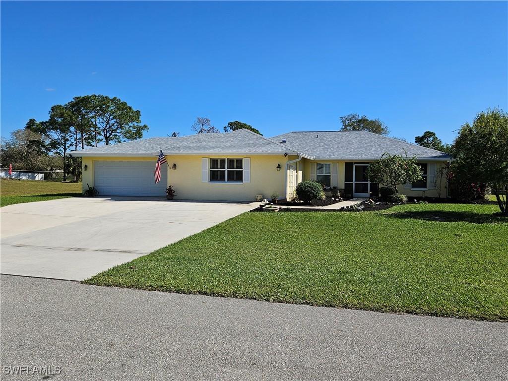 single story home featuring a garage and a front yard