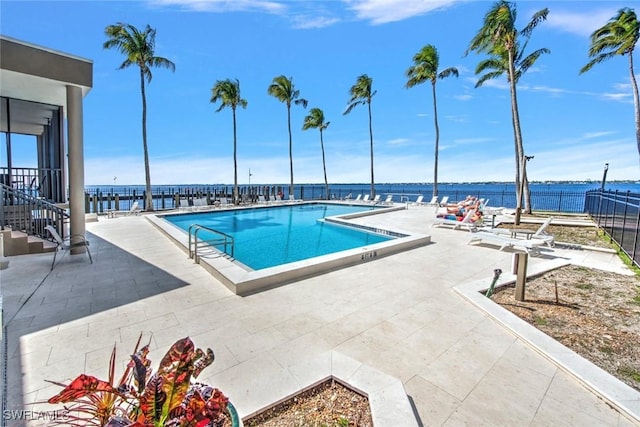 view of pool with a patio area and a water view