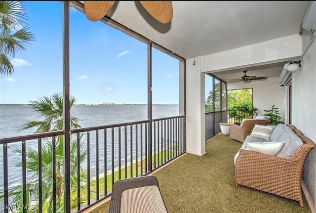 sunroom featuring a water view and ceiling fan