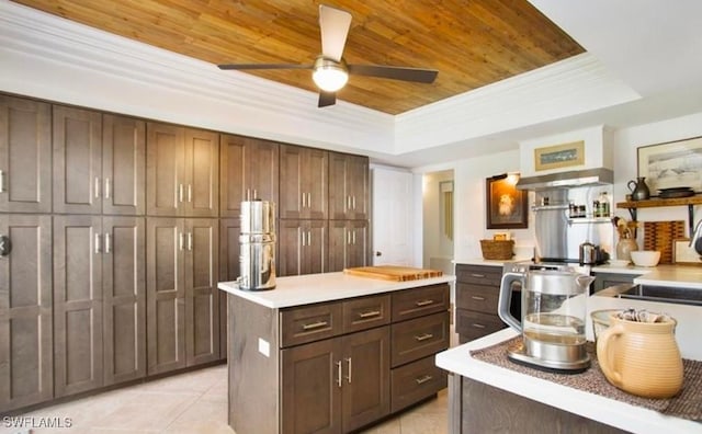 kitchen with a center island, a raised ceiling, wooden ceiling, light tile patterned floors, and dark brown cabinets