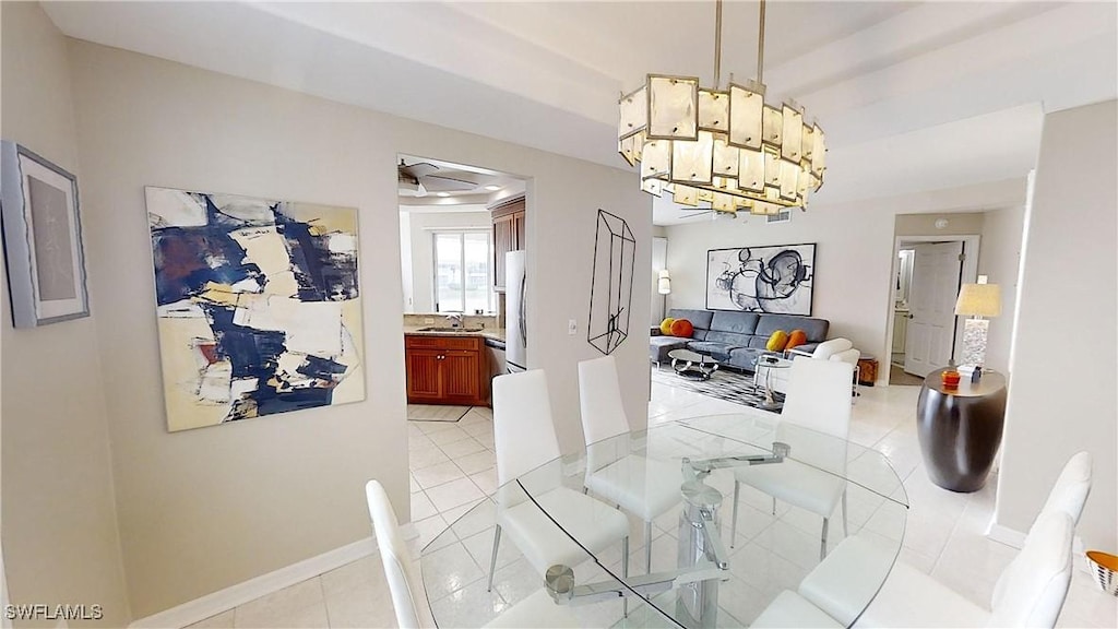 dining area featuring sink, light tile patterned floors, and a chandelier