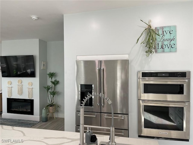 kitchen with appliances with stainless steel finishes and light stone countertops