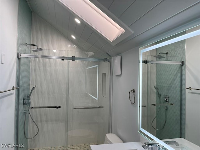 bathroom featuring lofted ceiling, a shower with shower door, and toilet