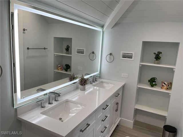 bathroom with hardwood / wood-style flooring, vanity, and built in features