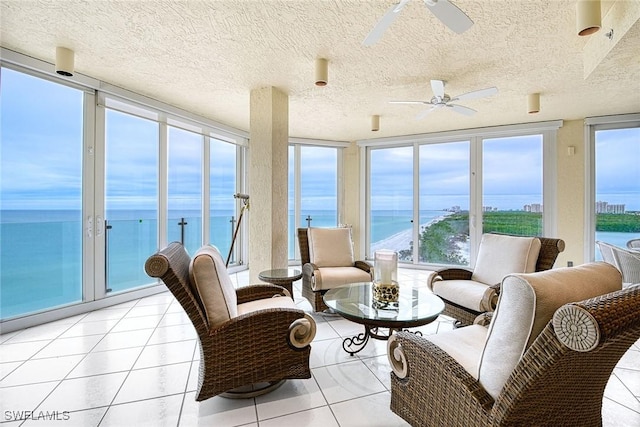 sunroom featuring a water view and ceiling fan