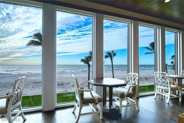 sunroom with a water view and a view of the beach