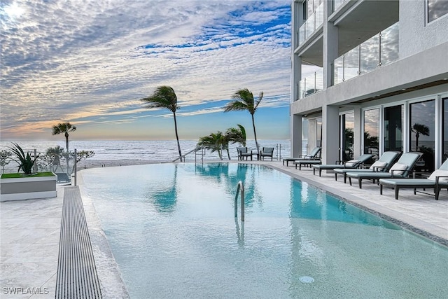 view of pool with a patio and a water view