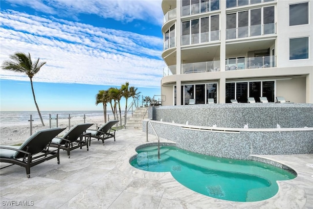 view of swimming pool featuring a patio and a water view