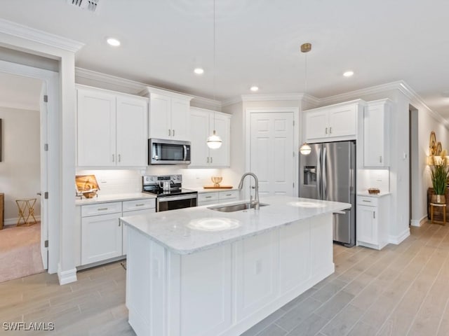 kitchen with sink, decorative light fixtures, white cabinets, and appliances with stainless steel finishes