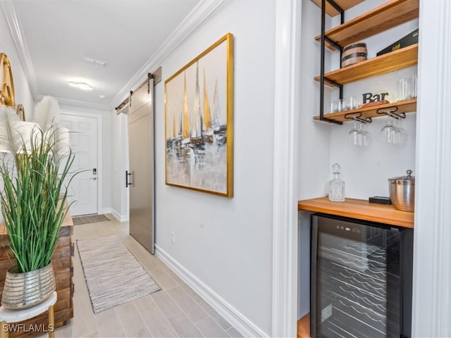 hallway with wine cooler, crown molding, and a barn door