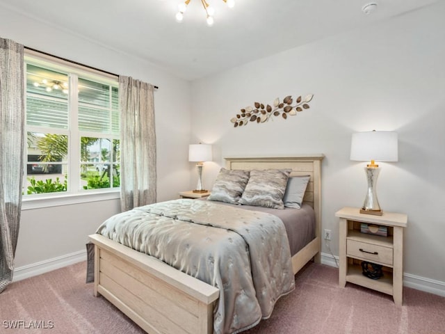 carpeted bedroom featuring an inviting chandelier