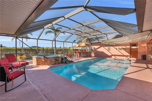 view of swimming pool with an outdoor hot tub, a lanai, and a patio area