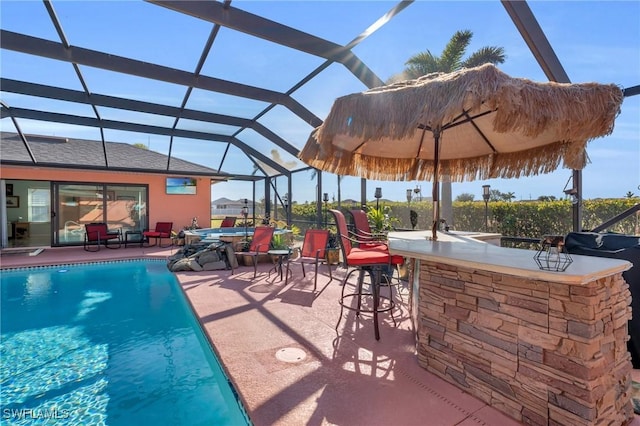 view of pool with a lanai, an outdoor bar, and a patio area