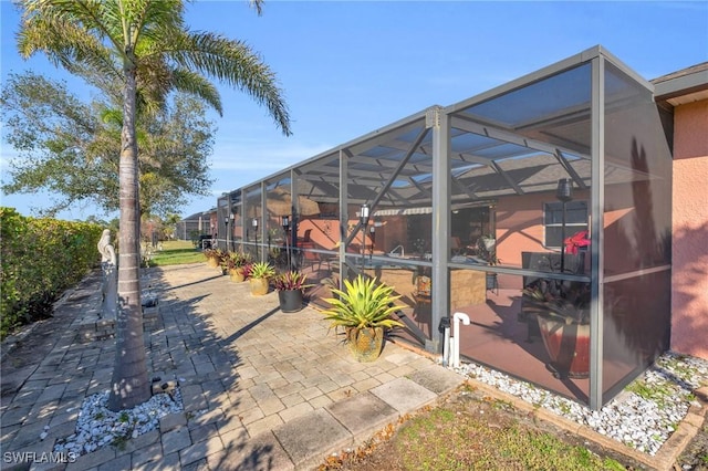 view of patio / terrace featuring glass enclosure