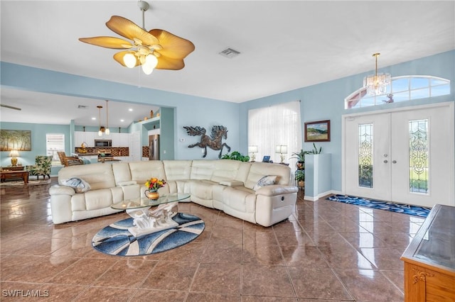 living room featuring plenty of natural light and ceiling fan with notable chandelier