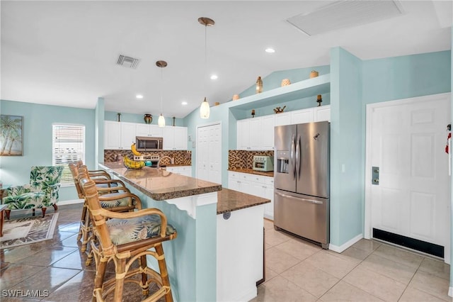 kitchen featuring light tile patterned flooring, a breakfast bar, white cabinetry, pendant lighting, and stainless steel appliances