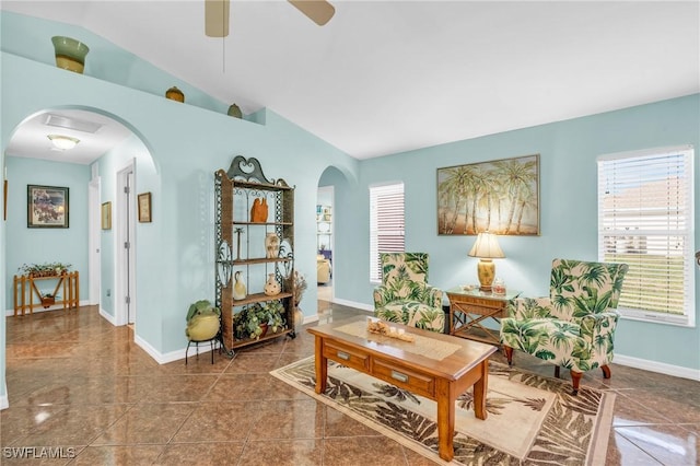 living area with lofted ceiling, tile patterned flooring, and ceiling fan